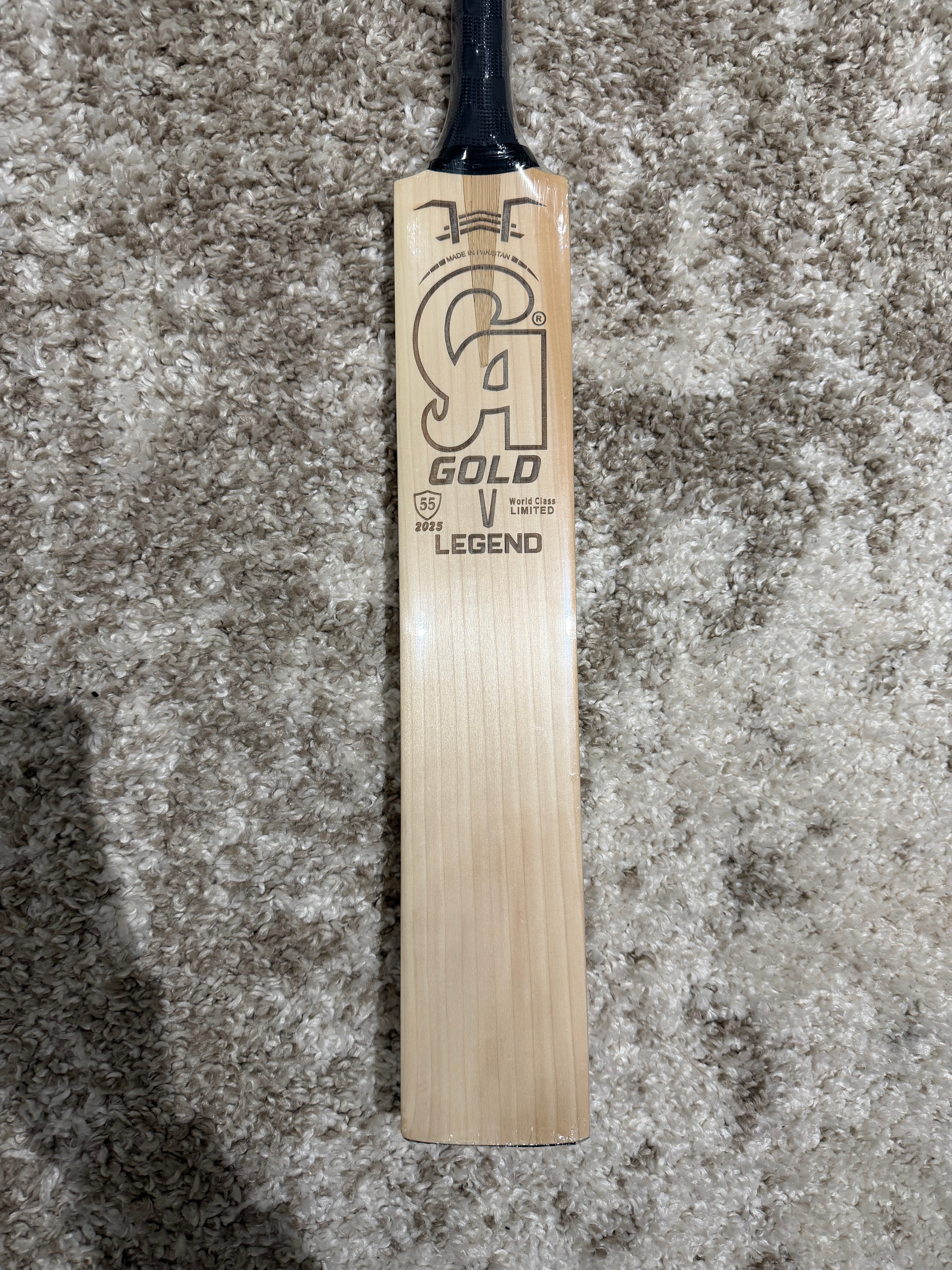 CA Legend english willow - Wooden cricket bat with branding on a textured surface